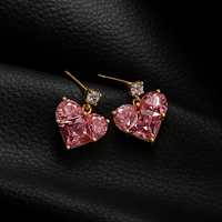 Pair of heart‑shaped earrings with pink stones and gold finish.