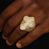 Ring with a cross motif on top, encrusted with sparkling stones and gold plating.