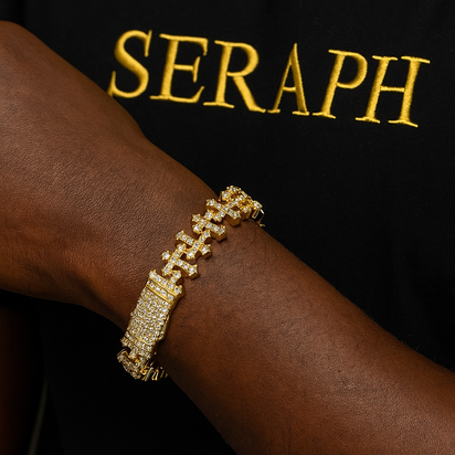 Cross shaped link bracelet with a row of gemstones and thick gold plating.