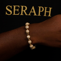 Thin chain bracelet with a small spherical charm and gold‑tone finish.