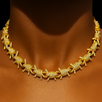 Barbed‑wire inspired chain necklace with shimmering stones and thick gold plating.